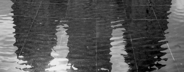 A black & white photograph of the Salt Lake City LDS (Mormon) Temple, reflected in the water of the reflecting pool. Photo by Paul Duane.